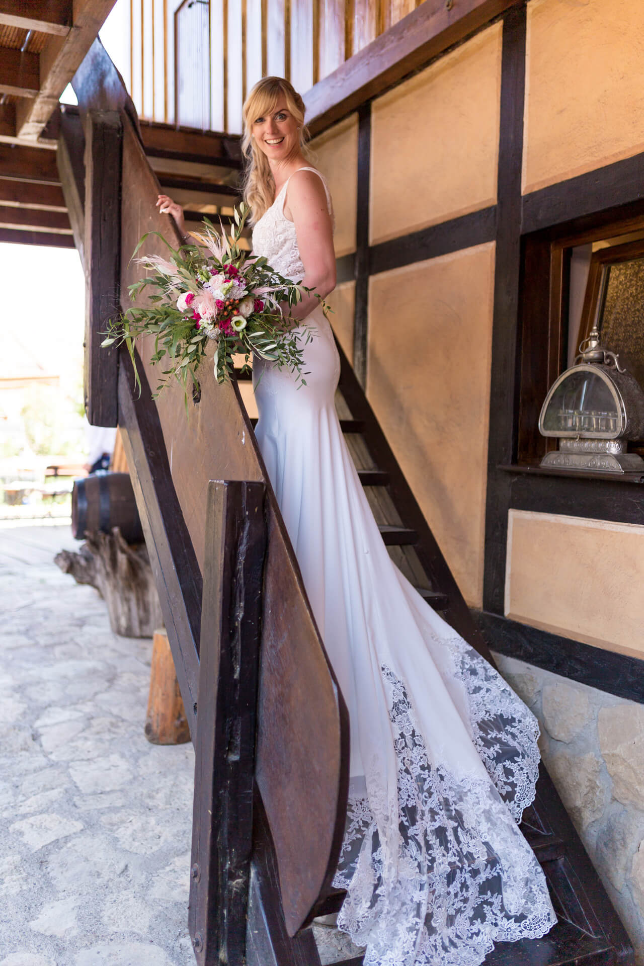 Freie Trauung im Weimarer Land. Braut post mit langem Hochzeitskleid auf der Treppe.