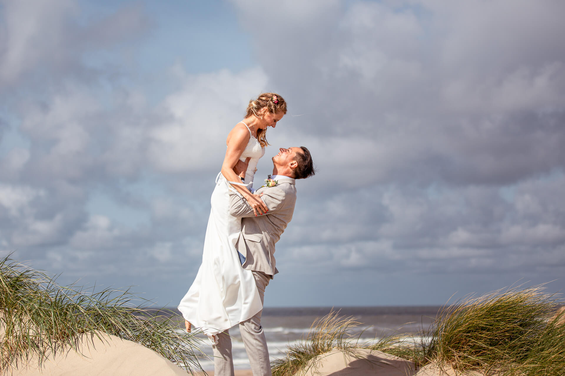 Bräutigam hebt Braut Hoch am Strand