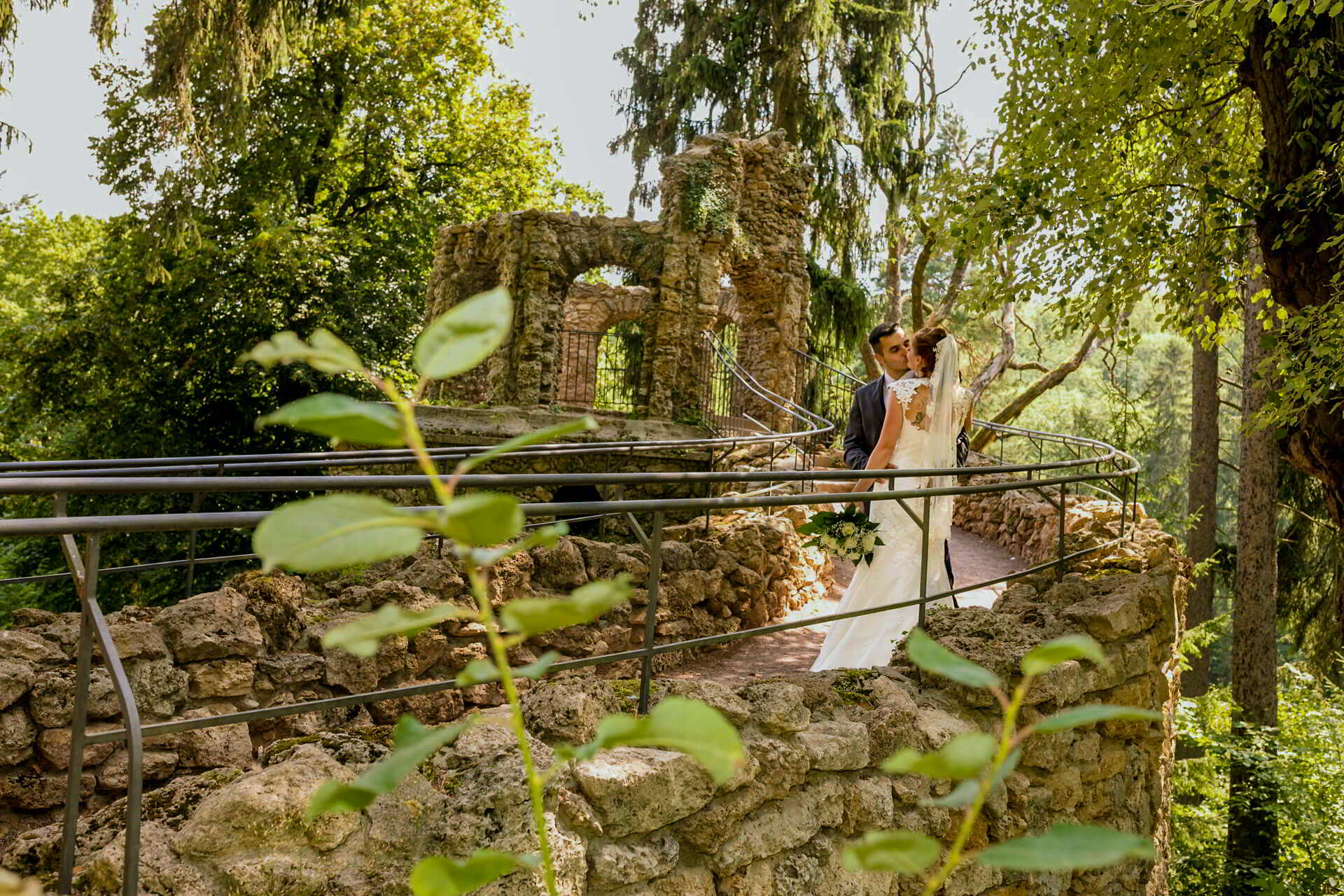 Braut im verwunschenen Garten Braut steht in einem grünen Garten mit alten Steinmauern